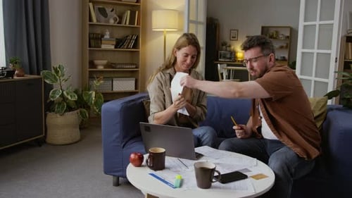 Couple reviewing household finances and paperwork at home