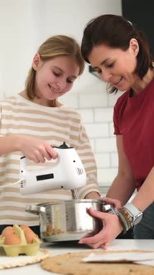 Girl and Woman Baking in Kitchen Together