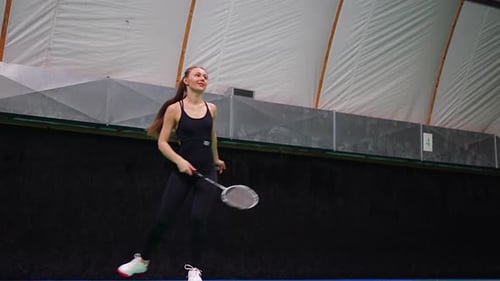 Sports Young Woman with Racket and Shuttlecock is Exercising Playing in Badminton on Inside Court