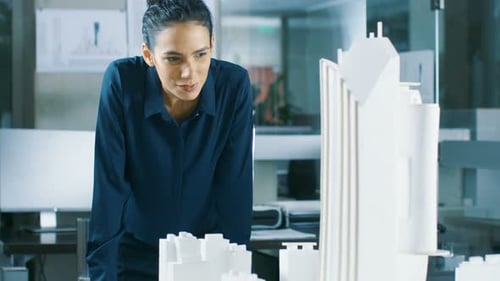 Female Architectural Designer Works on a Model of a City District with Buildings, Parks and It's Ow