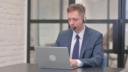 Man Wearing Headset Working On Laptop