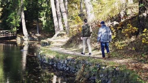 Senior Father and Son Walk by Lake