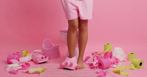 Mulher irreconhecível relaxa no banheiro posando contra fundo rosa