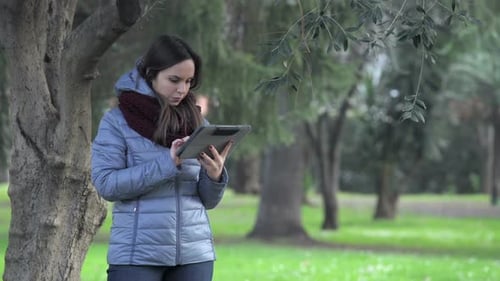 young woman in a park with tablet