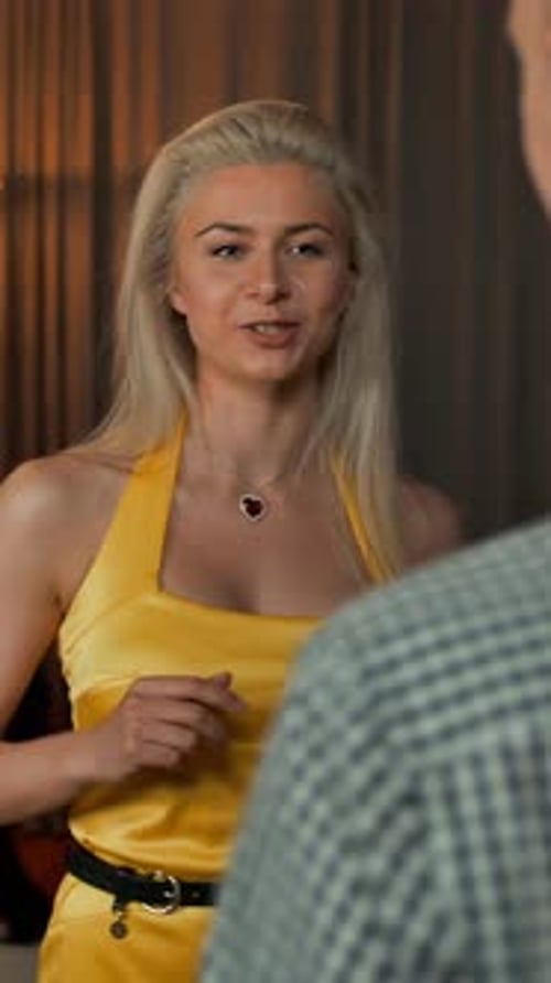 Woman in Yellow Dress Toasts with Champagne at Party
