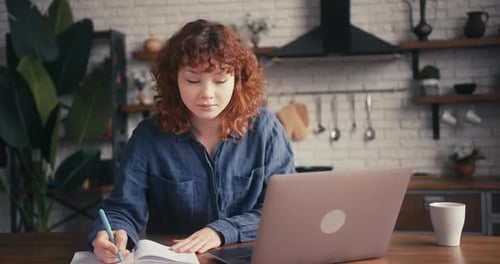 Woman Works at Laptop in Sunny Kitchen