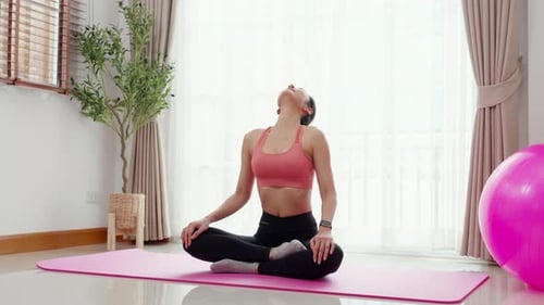 Woman Practices Yoga in Bright Home Studio