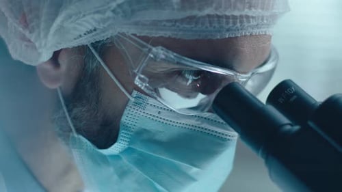 Wissenschaftlerin mit Maske, Mikroskop und Schreiben von Forschungsergebnissen