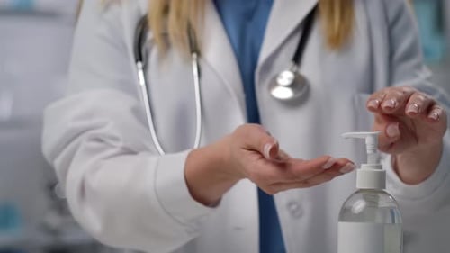 Doctor Using Hand Sanitizer in Hospital Close Up