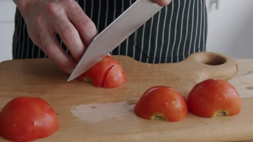 Chef coupant des tomates sur une planche prise de vue à 100 images par seconde (2,8 k
) réduite à 1080p