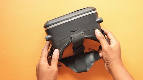 Hands Adjusting Black Virtual Reality Headset