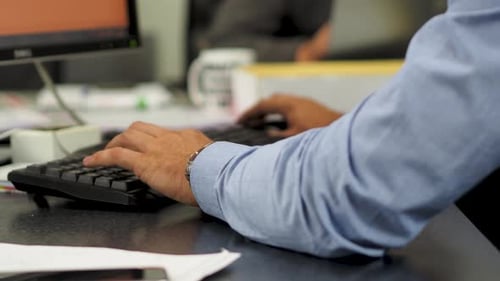 Businessman typing on computer keyboard working in office.