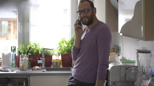Man with Glasses Talking on Phone in Kitchen