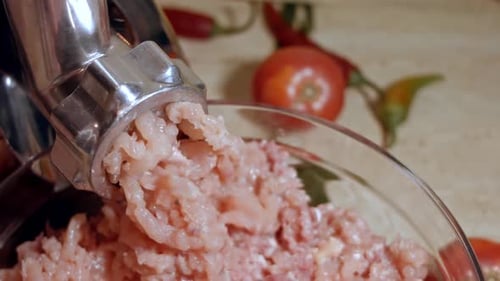A carne é rolada através de um moedor de carne