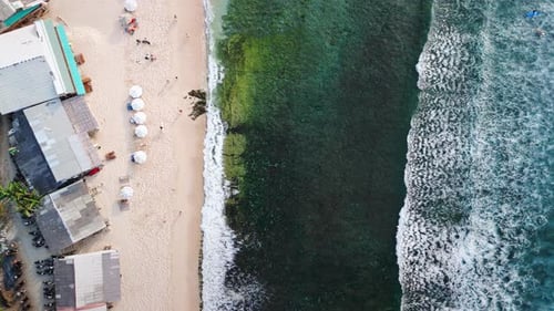 Playa tropical con sombrillas y océano con olas con vista desde arriba desde un Zumbido en Bali
