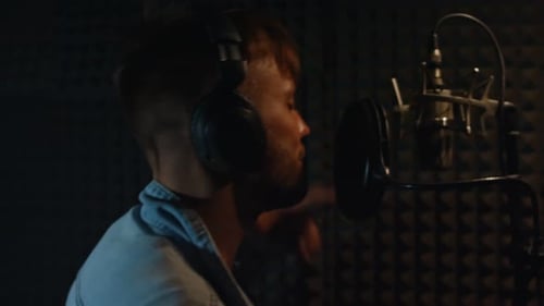 Man Recording Voiceover in Soundproof Recording Studio Booth