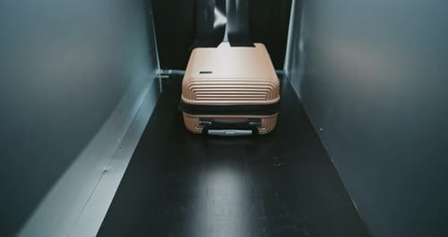 Suitcase on Conveyor Belt in Dark Room