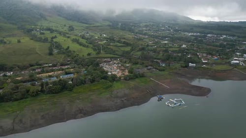 Flying Over Lake with Clouds and Mountains in the Background
