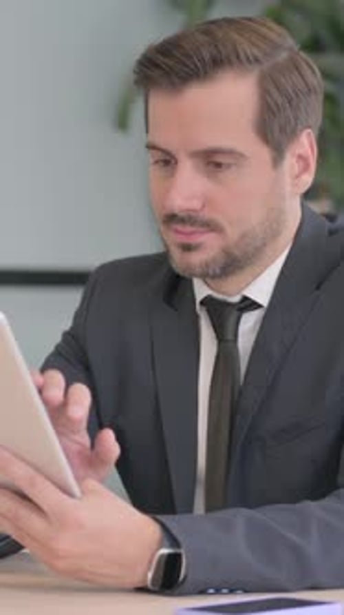 Man in Suit Using Tablet at Office Desk