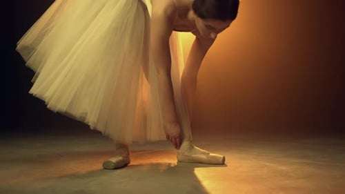 Female Ballet Dancer Tying Pointe Shoes Preparation