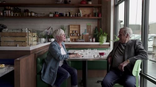 Senior Couple Drinking Coffee at Cafe Table 6064 Years