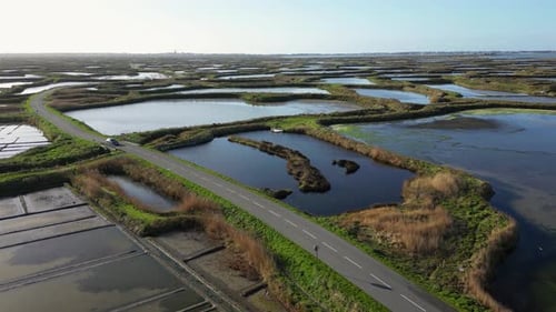 Aerial View of a Car Driving Between Massive Salt Marshes Near Guerande France