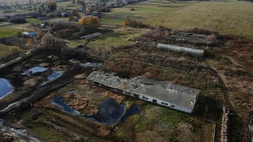 Aerial shot of the destroyed cattle barn and explosion crater, real war in Ukraine