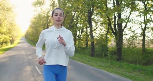 Caucasian Young Beautiful Woman Athlete Running on Street Outside the City Alone Pretty Happy