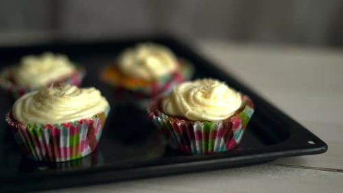Delicious frosted cupcakes sitting on a baking sheet