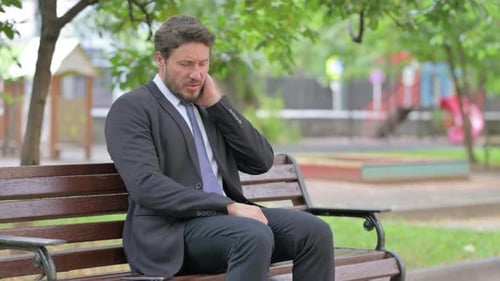 Man in Suit Sitting on Park Bench