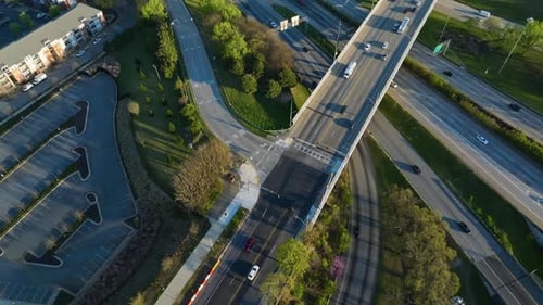 Busy traffic scene with cars and trucks on american interstate road at sunset time. Green trees and