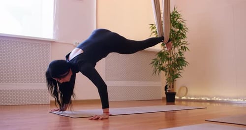 Woman Doing Aerial Yoga in Bright Studio
