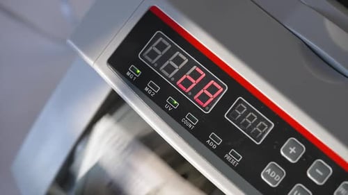 Money Counter Counts Stacks of Hundred Dollar Bills