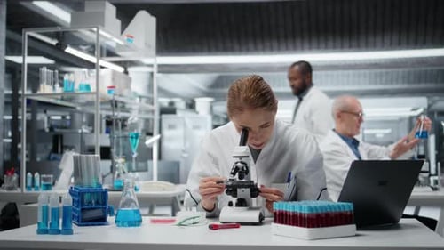 Female Scientist Using Microscope in Modern Laboratory