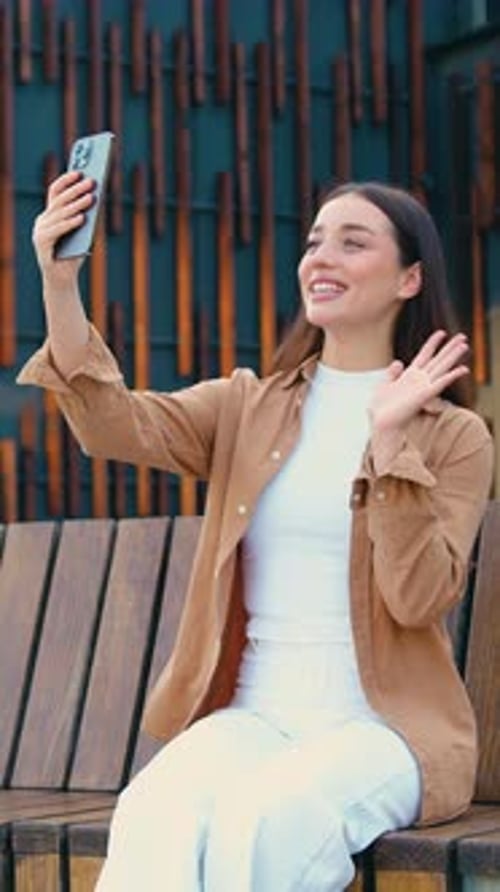 Close Up of Smiling Caucasian Businesswoman Talking on Video Call Using Phone Outdoors While Sitting