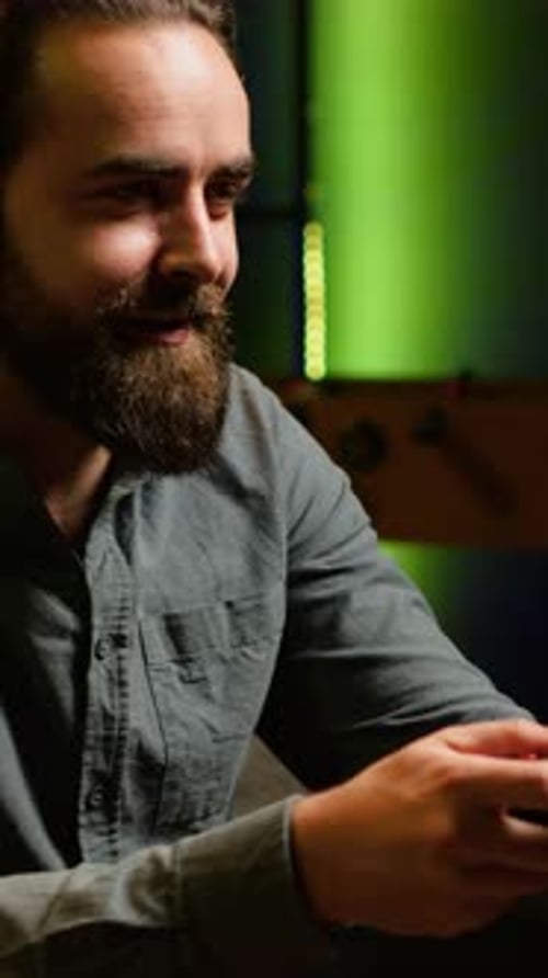 Young Adult Gaming Wearing Headphones at Home