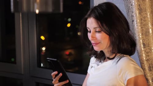 Jovem mulher está percorrendo seu feed de mídia social rindo