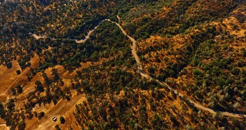 Wellenförmige Autobahn, die sich entlang der trockenen Landschaft mit etwas Grün erstreckt.