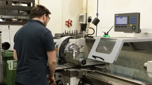 Trabalhador de fábrica operando fresagem CNC com vista lateral