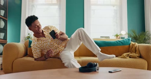 Man Relaxing on Couch Using Cell Phone Indoors