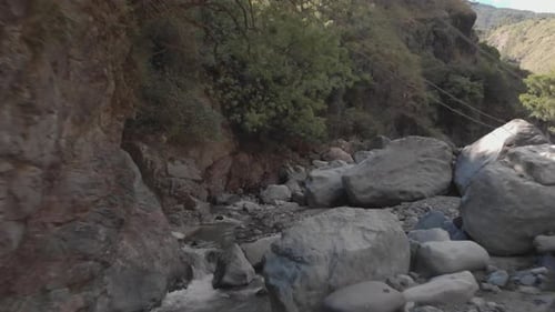 mountain water river creek winding through rock boulders wilderness flowing downstream close proximi