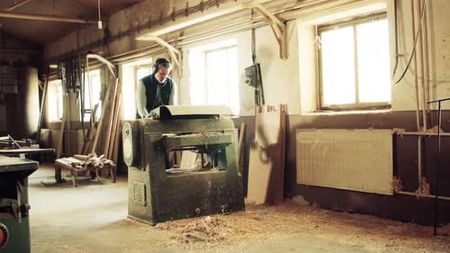 A Man Worker in the Carpentry Workshop, Working with Wood