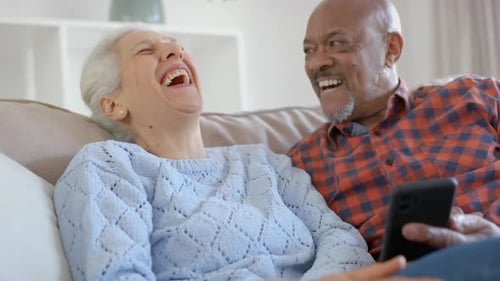 Senior Couple Laughing Together at Phone