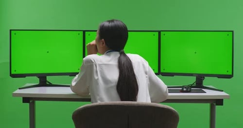 Tired Asian Woman Yawning While Working With Mock Up Multiple Computer Monitor In Green Screen
