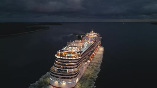 Aerial View of a Luxury Cruise Ship Leaving the Harbor at Full Speed at Night
