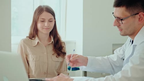 Doctor Consulting with Young Adult Female Patient