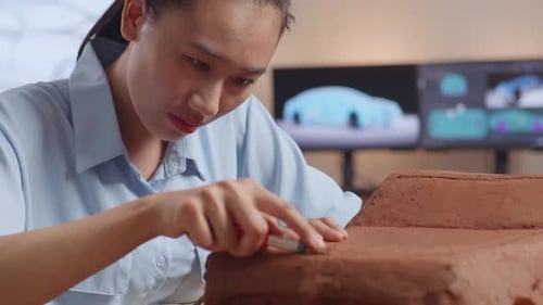 Close Up Of Asian Woman Automotive Designer Works On The Sculpture Of Car Clay