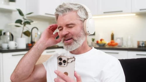 Man with Headphones Enjoys Music in Kitchen