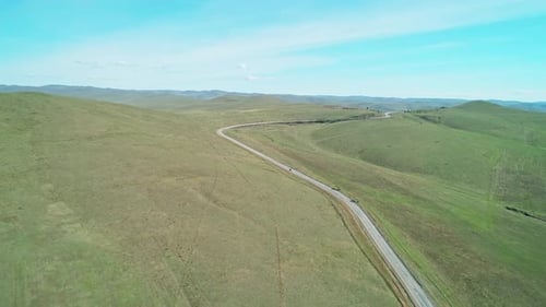 Aerial View of an Asphalt Road Through the Rural Countryside Area Wavy Road Between Little Hills