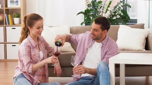 Couple Pouring Red Wine in Bright Modern Home